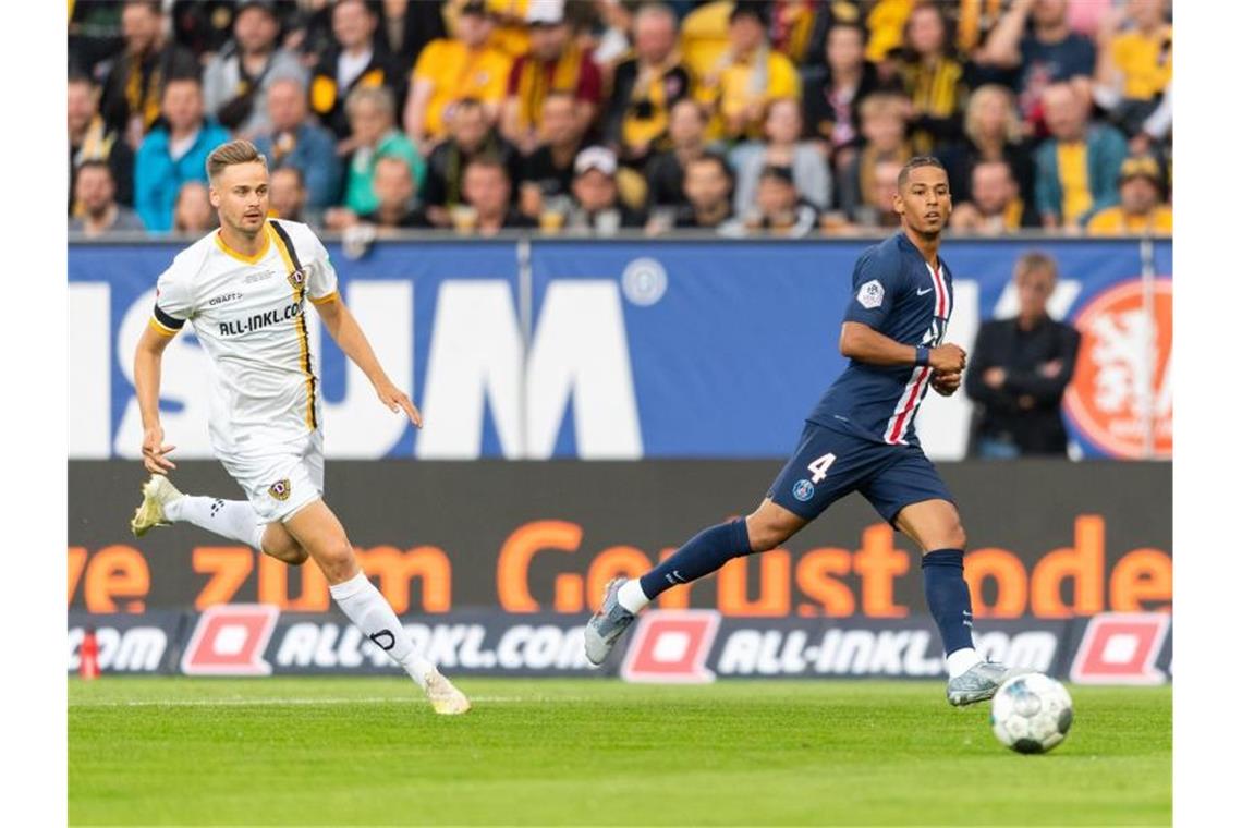 Mbappé-Show bei PSG-Torfestival bei Dynamo Dresden Den Ball im Blick: PSG's Thilo Kehrer (r) und Dynamos Lucas Röser. Foto: Robert Michael