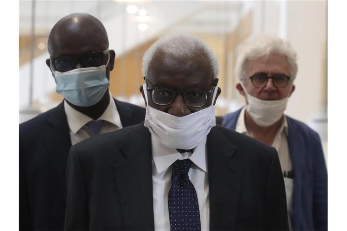 Den Corona-Regeln entsprechend mit einer Maske kommt Lamine Diack (M) mit seinem Anwalt William Bourdon (r) ins Pariser Gericht. Foto: Thibault Camus/AP/dpa
