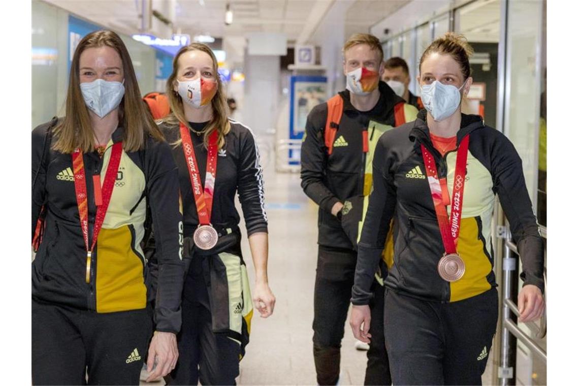 Denise Herrmann, Franziska Preuß, Roman Rees und Vanessa Hinz (l-r) kommen nach den Winterspielen am Frankfurter Flughafen an. Foto: Helmut Fricke/dpa