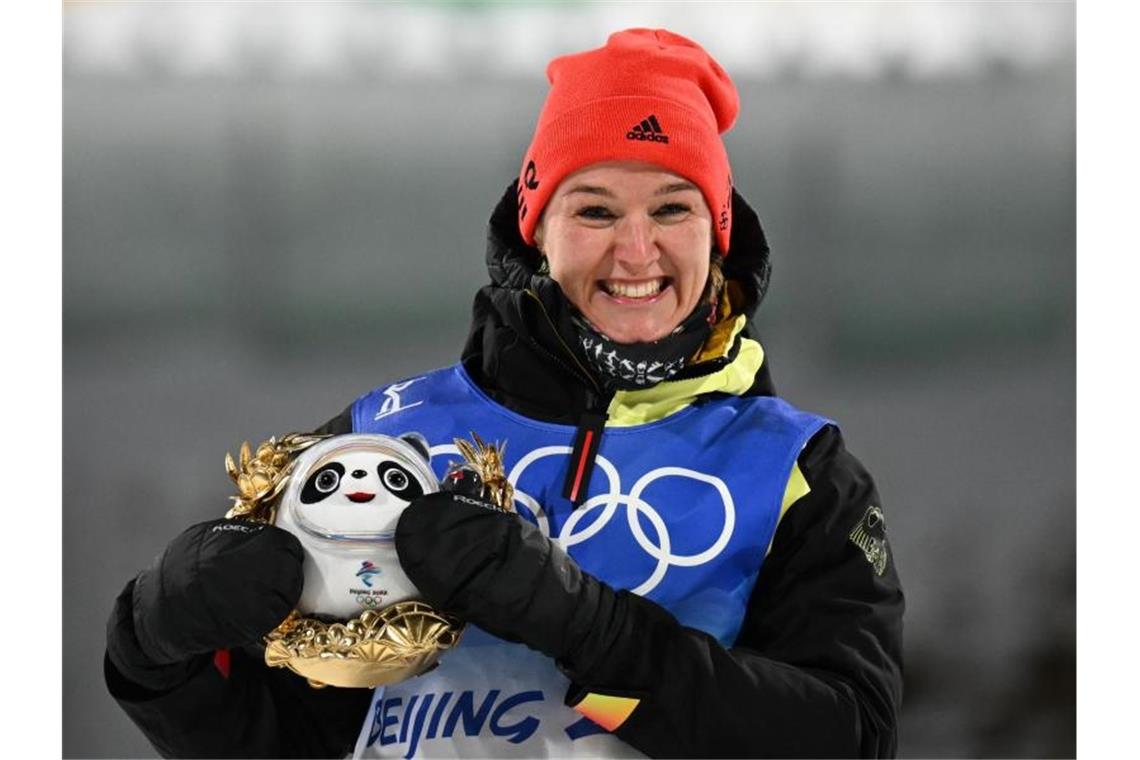 Herrmann zeigt es mit Gold-Coup allen: „Das perfekte Rennen“ Denise Herrmann freut sich bei der Flower Ceremony über den Gewinn der Goldmedaille. Foto: Hendrik Schmidt/dpa-Zentralbild/dpa