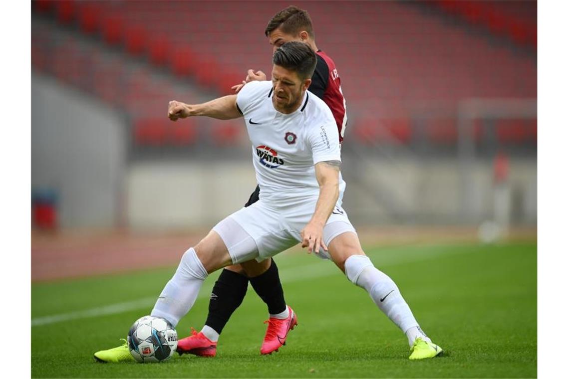 Dennis Kempe aus Aue (v) schirmt den Ball gegen Nikola Dovedan ab. Foto: Matthias Hangst/Getty Images Europe/Pool/dpa