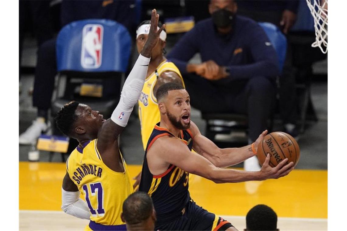 LeBron James wirft die Lakers in die NBA-Playoffs Dennis Schröder (l) setzte sich mit den Los Angeles Lakers gegen die Golden State Warriors, mit Stephen Curry durch. Foto: Mark J. Terrill/AP/dpa
