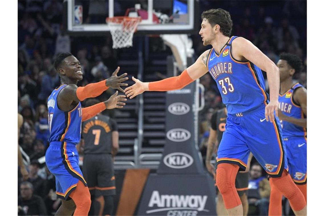 Dennis Schröder (l) von den Oklahoma City Thunder jubelt mit seinem Teamkollegen Mike Muscala über einen Punktgewinn. Foto: Phelan M. Ebenhack/AP/dpa