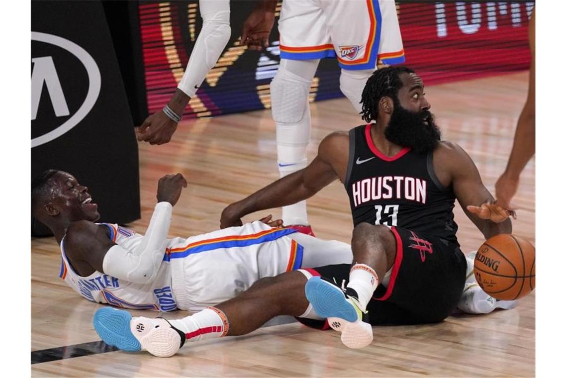 Dennis Schröder (l) von den Oklahoma City Thunder und Houstons Star James Harden im Zweikampf. Foto: Mark J. Terrill/AP/dpa