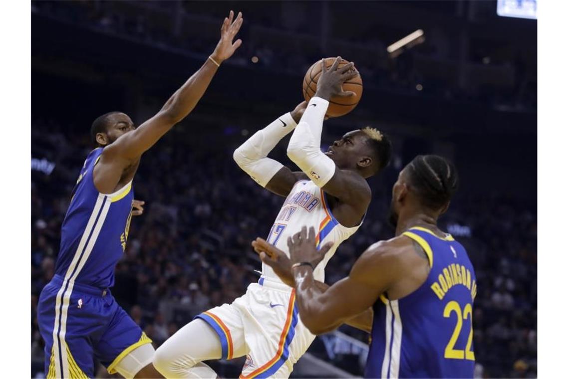 Dennis Schröder (M) von Oklahoma City Thunder in Aktion am Korb. Foto: Ben Margot/AP/dpa