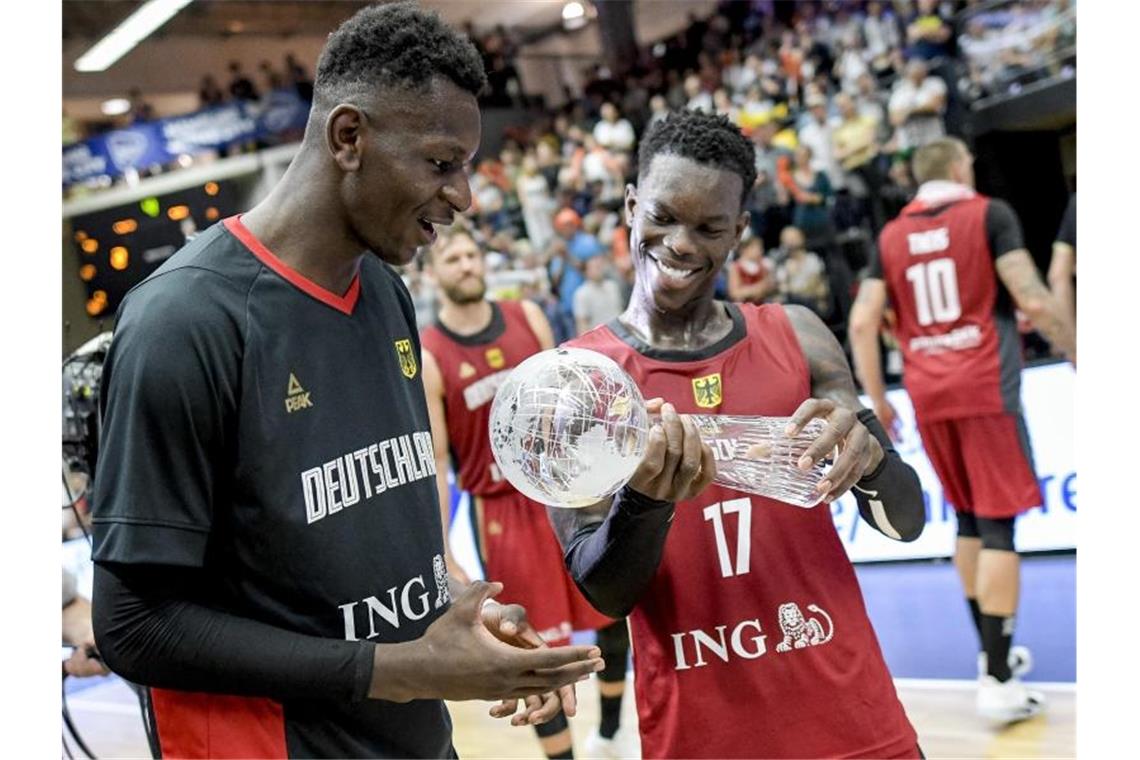 Dennis Schröder (r) und Isaac Bonga halten den Pokal in den Händen. Foto: Axel Heimken