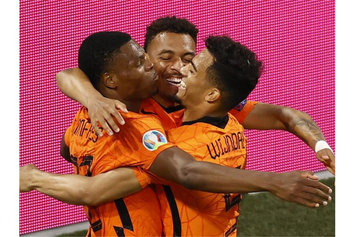Niederlande spielt sich in Favoritenkreis - Bondscoach mahnt Denzel Dumfries (l) von den Niederlanden feiert mit seinen Teamkollegen das zweite Tor seiner Mannschaft. Foto: Koen Van Weel/EPA Pool/AP/dpa