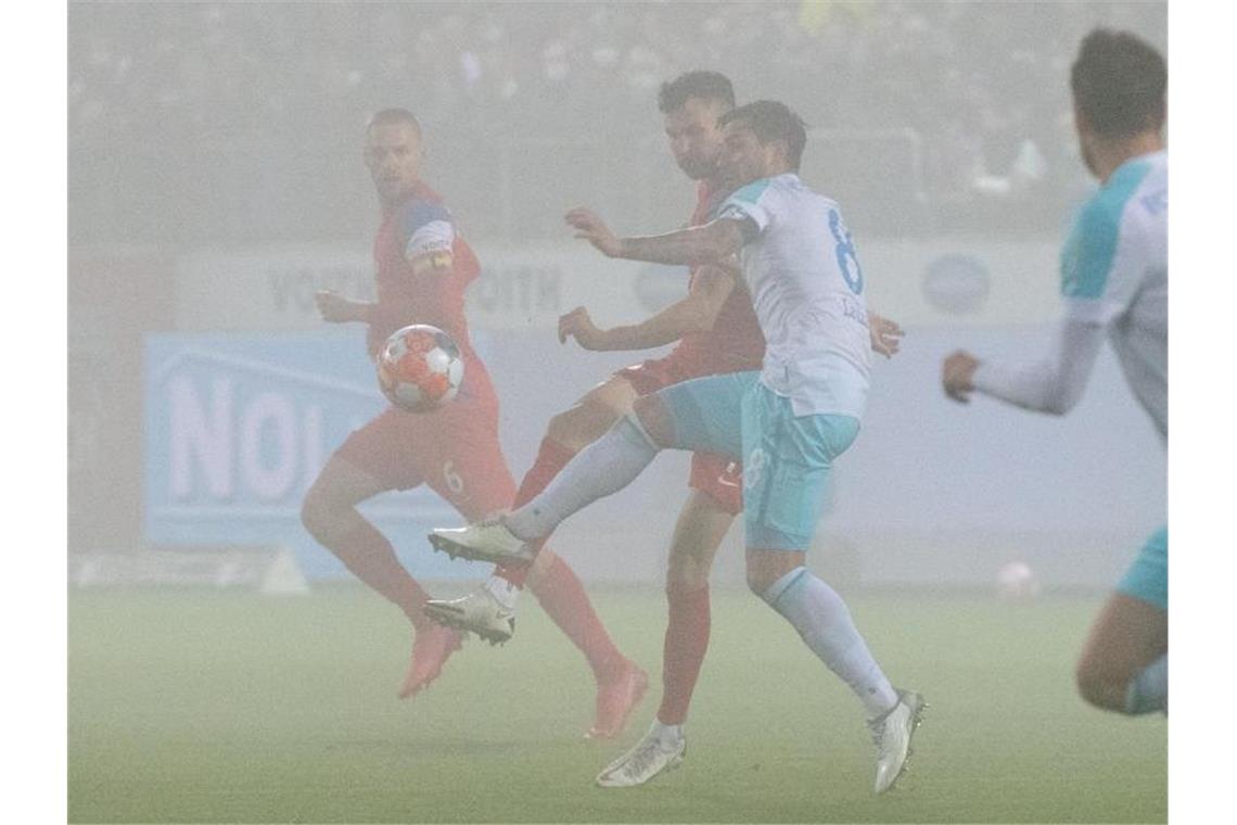 Der 1. FC Heidenheim (rote Trikots) kam gegen Schalke 04 zu einem Last-Minute-Sieg. Foto: Stefan Puchner/dpa