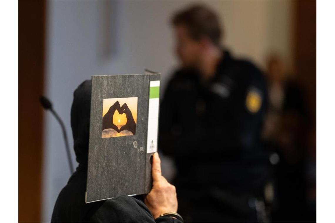 Verschwundenes Mädchen Maria: Begleiter erhält Haftstrafe Der 58-jährige Angeklagte sitzt im Gerichtssaal und hält einen Aktenordner mit einem Herz aus zwei Händen vor sein Gesicht. Foto: Patrick Seeger/Archivbild
