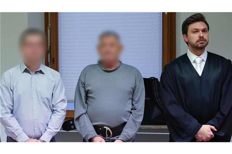 Der 71 Jahre alte Angeklagte aus den USA (M) steht zu Prozessbeginn zwischen dem Übersetzer (l) und seinem Strafverteidiger Johannes Makepeace (r) im Sitzungssaal am Landgericht Schweinfurt.