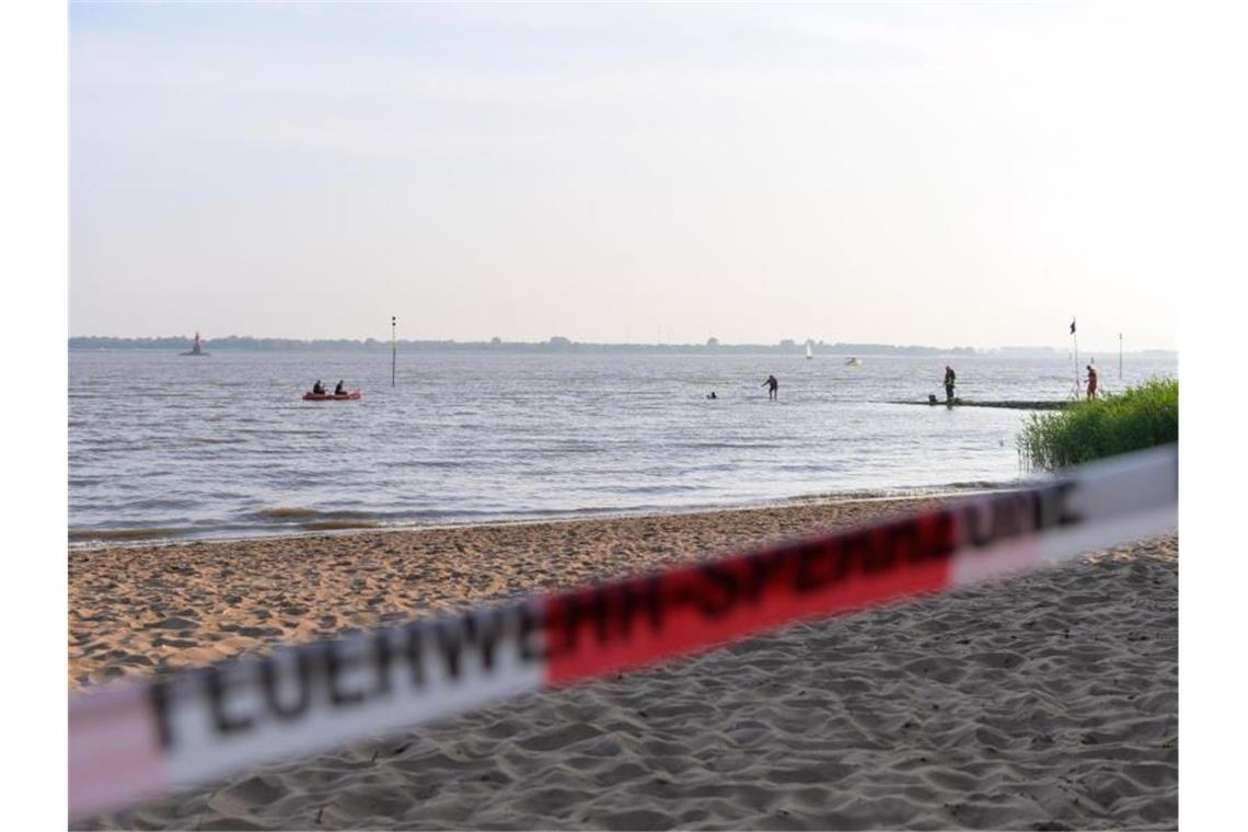 Tote und Vermisste nach Badeunfällen an Seen und Flüssen Der abgesperrte Badestrand an der Elbe. Foto: Jonas Walzberg/dpa