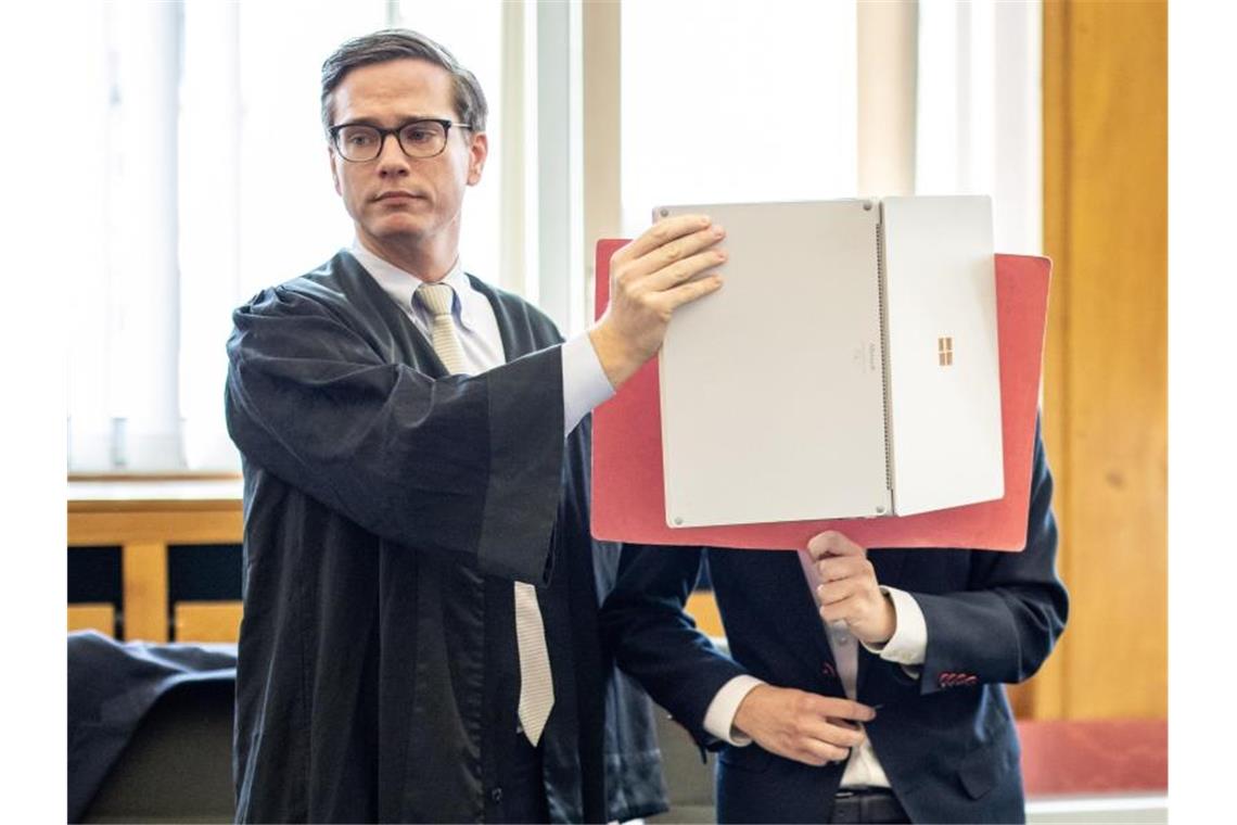 Der Angeklagte, der sein Gesicht neben seinem Anwalt mit einer Mappe verdeckt, wurde nach einem tödlichen Unfall zu einer Bewährungsstrafe verurteilt. Foto: Marcel Kusch/dpa