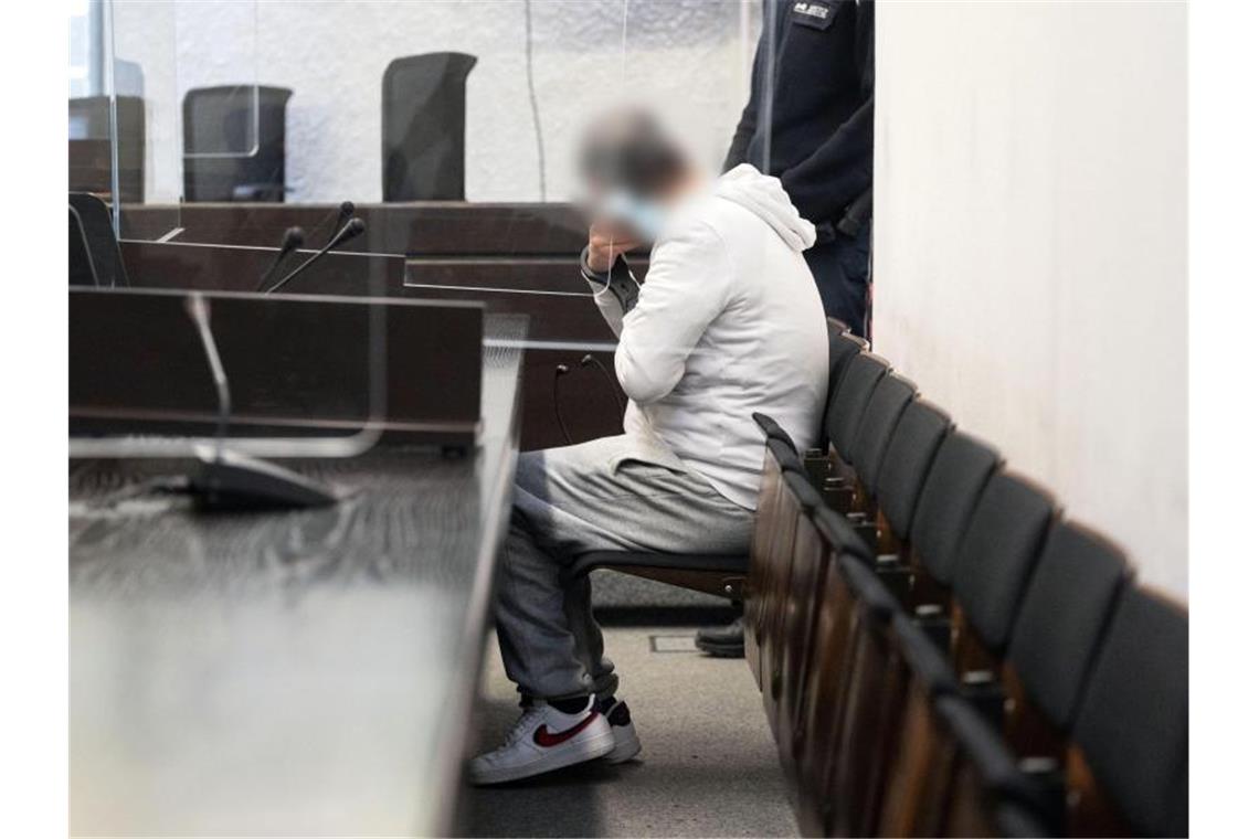 Der Angeklagte in einem Mordprozess sitzt auf einer Bank im Landgericht Stuttgart. Foto: Marijan Murat/dpa/Aktuell