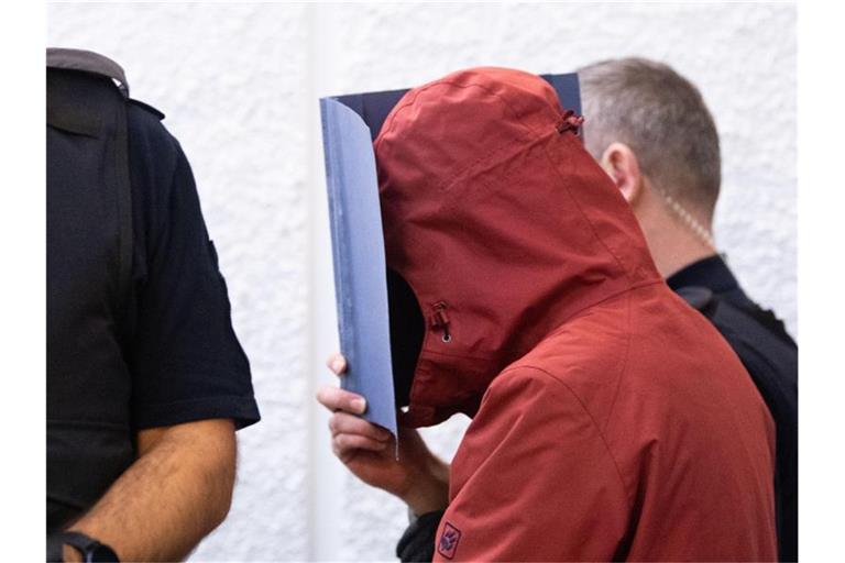 Der Angeklagte in einem Prozess nach einem tödlichem Unfall wird in einem Gerichtssaal des Landgerichts Stuttgart an seinen Platz geführt. Foto: Marijan Murat/dpa