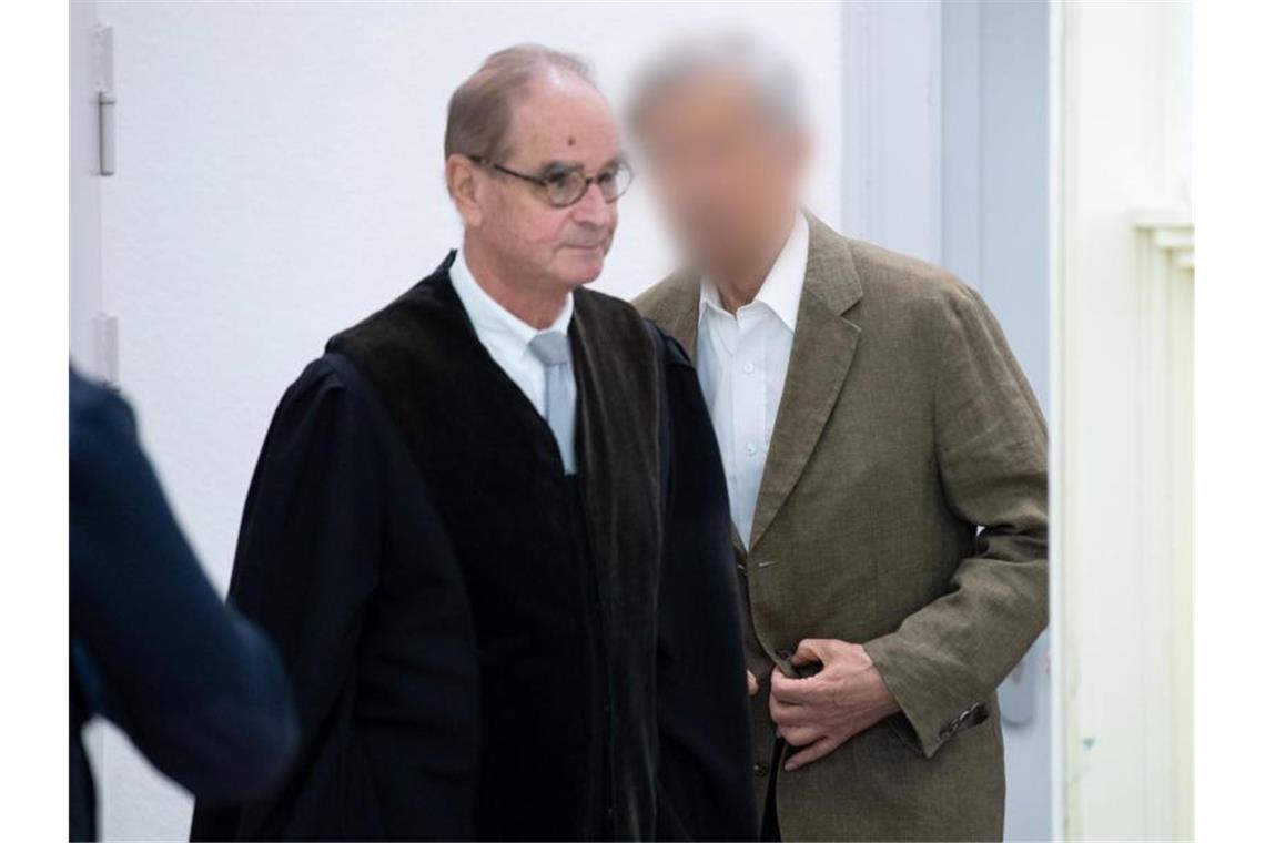 80-jähriger Serienbankräuber verurteilt Der Angeklagte (r) geht mit seinem Rechtsanwalt zur Anklagebank. Foto: Tom Weller/dpa