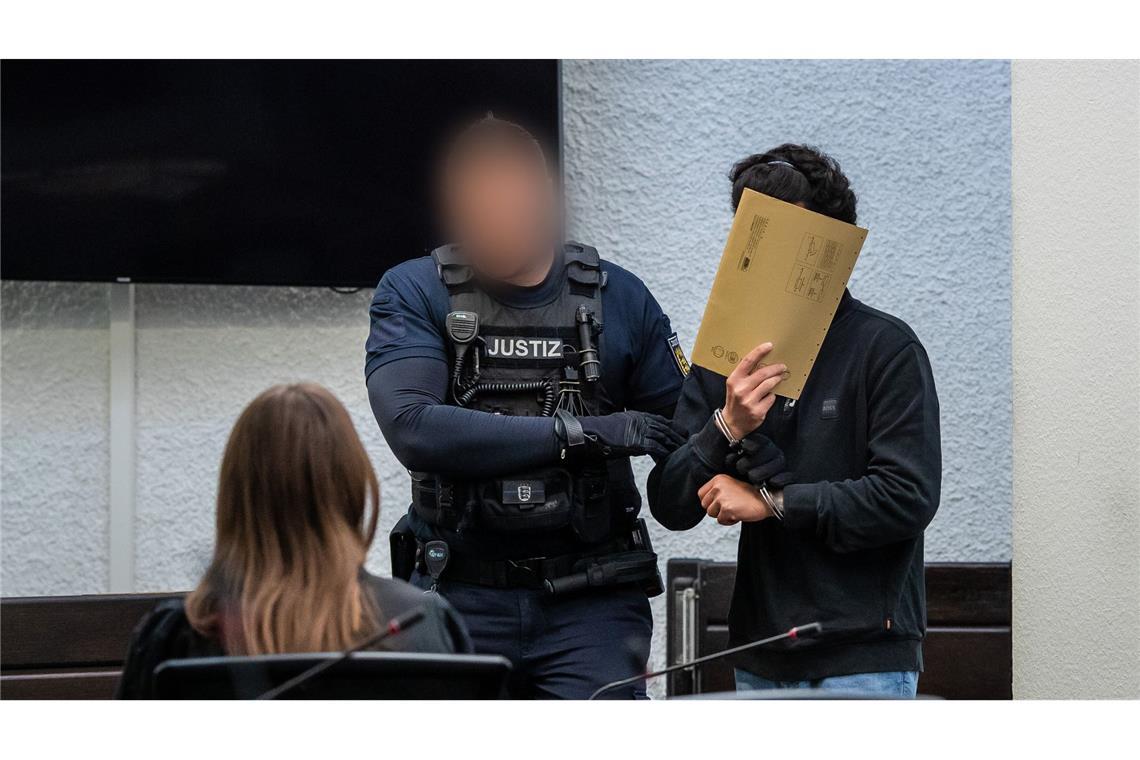 Der Angeklagte (rechts) wird in der Gerichtssaal geführt.