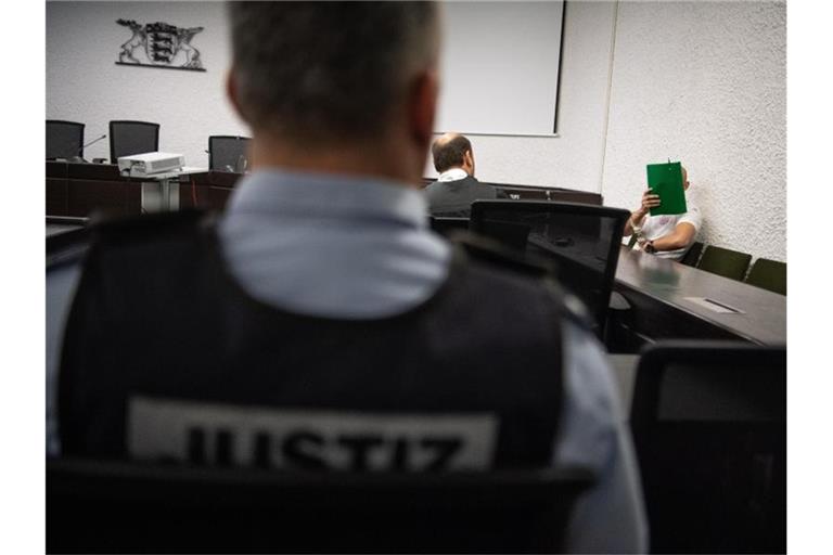 Der Angeklagte sitzt im Gerichtssaal des Oberlandesgerichts neben seinem Anwalt Marvin Schroth (M) auf der Anklagebank. Foto: Fabian Sommer