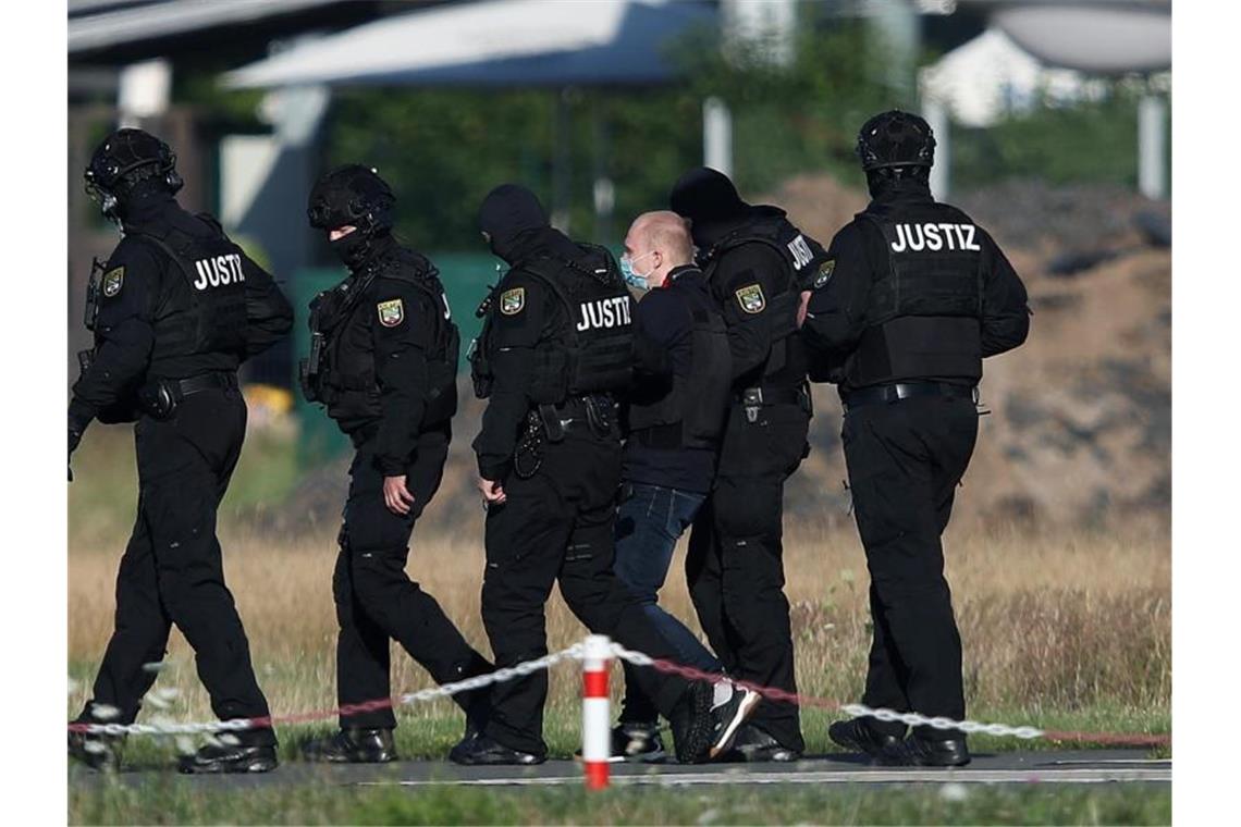 Der Angeklagte Stephan Balliet wird vor dem vierten Prozesstag von Justizbeamten aus dem Hubschrauber gebracht. Foto: Ronny Hartmann/dpa