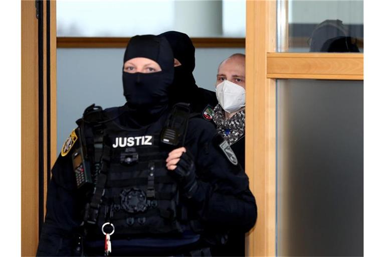 Der angeklagte Stephan Balliet wird zu Beginn des 22. Prozesstages am 1. Dezember von Justizbeamten in den Verhandlungssaal geführt. Foto: Ronny Hartmann/dpa-Zentralbild/dpa
