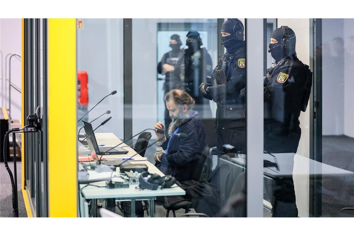 Der Angeklagte Taleb al-Abdulmohsen sitzt mit Handfesseln in dem kugelsicheren Glaskasten im temporären Gerichtsgebäude des Landgerichtes Magdeburg.