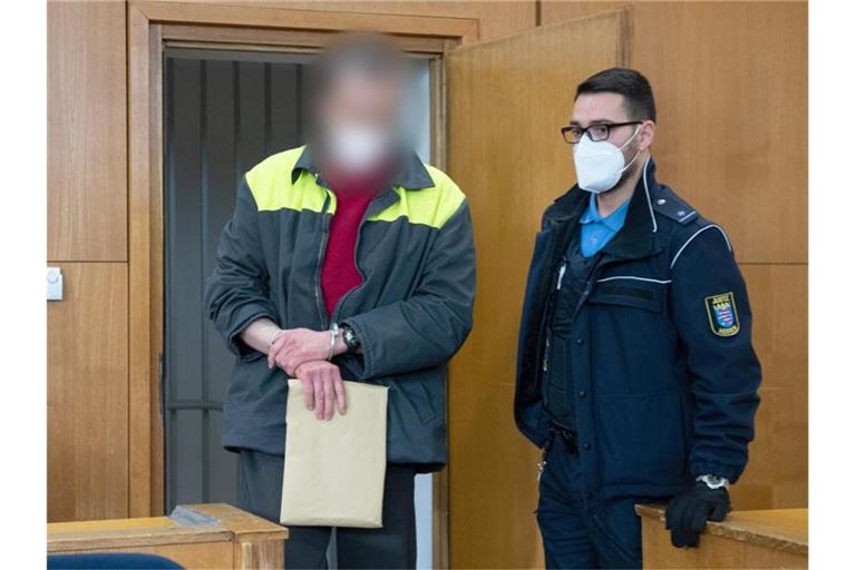 Der Angeklagte und mutmaßliche Verfasser der „NSU 2.0“-Drohschreiben wird mit Handschellen in den Verhandlungssaal geführt. Foto: Boris Roessler/dpa Pool/dpa