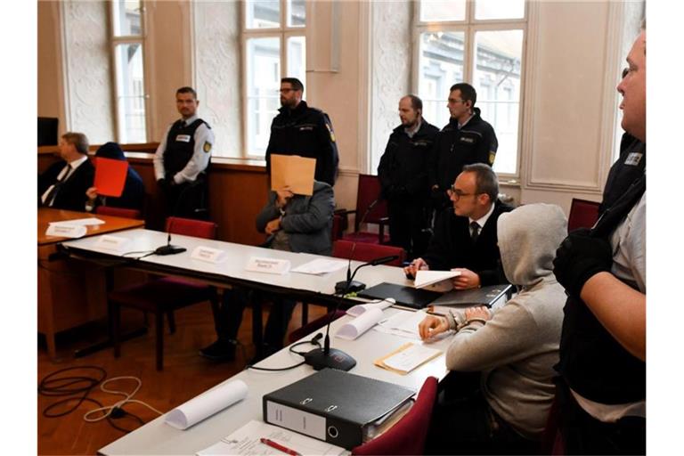 Der angeklagte Vater (M.) mit seinen Söhnen (l. und 2. v. r.) im Landgericht in Ellwangen. Foto: Stefan Puchner/dpa