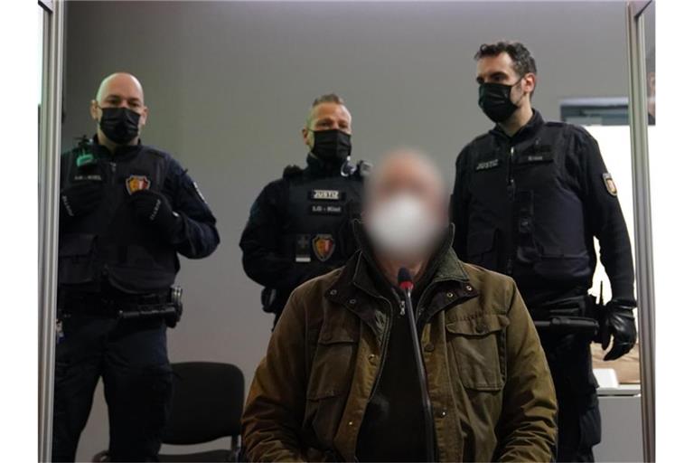 Der Angeklagte (vorne) zu Beginn des Prozesses wegen eines Dreifachmordes im Landgericht Kiel. Foto: Marcus Brandt/dpa