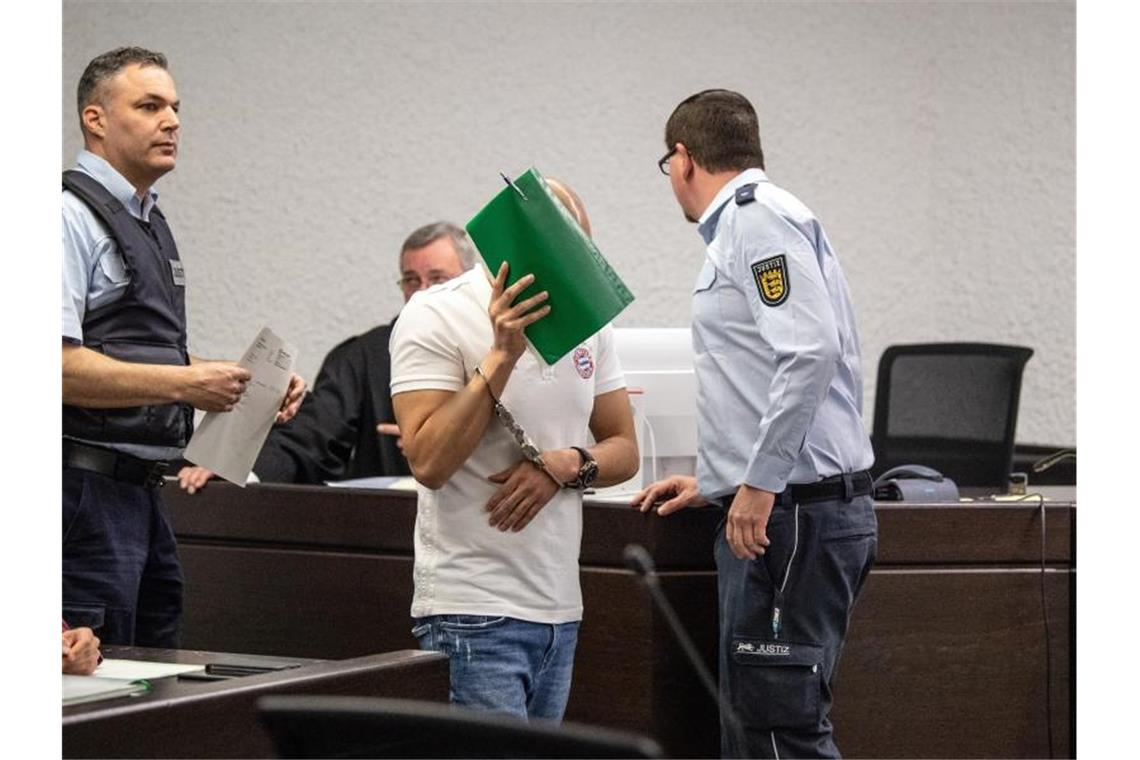 Der Angeklagte wird von Justizbeamten in den Gerichtssaal des Oberlandesgerichts geführt. Foto: Fabian Sommer/Archivbild
