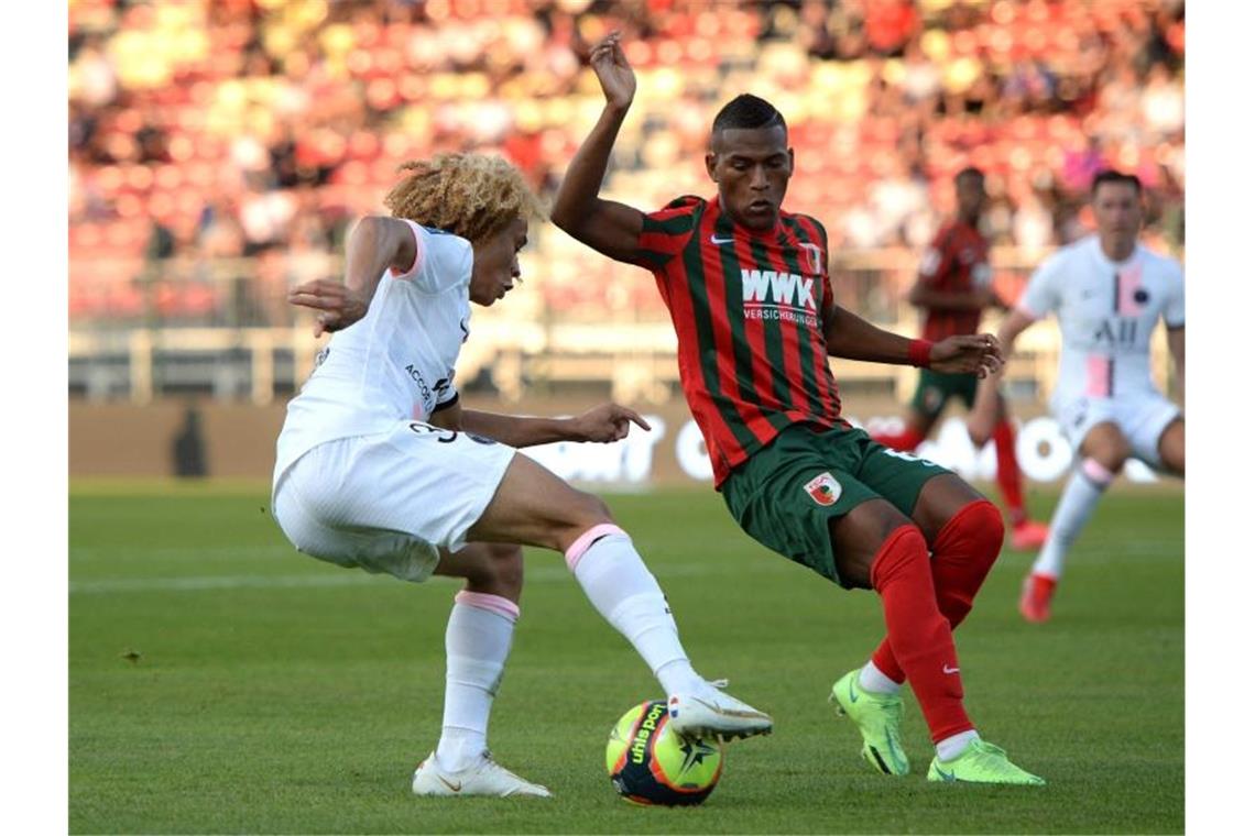 FC Augsburg mit unglücklicher Niederlage gegen PSG Der Augsburger Carlos Gruezo (r) im Zweikampf mit PSG-Talent Xavi Simons. Foto: Guillaume Souvant/AFP/dpa