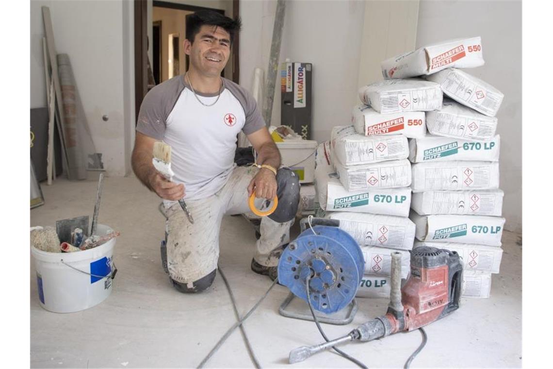 Der aus Afghanistan geflohene Najibullah Alizadah arbeitet auf einer Baustelle auf dem Gelände der Universität. Der aus der Nähe von Kabul stammende Mann absolvierte eine Maler-Ausbildung bei einem mittelständischen deutschen Betrieb. Foto: Boris Roessler/dpa