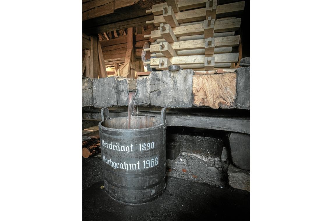 Ein Denkmal des Landes in Aktion Der ausgepresste Saft läuft unter der Vorrichtung hervor und sammelt sich im Eimer.