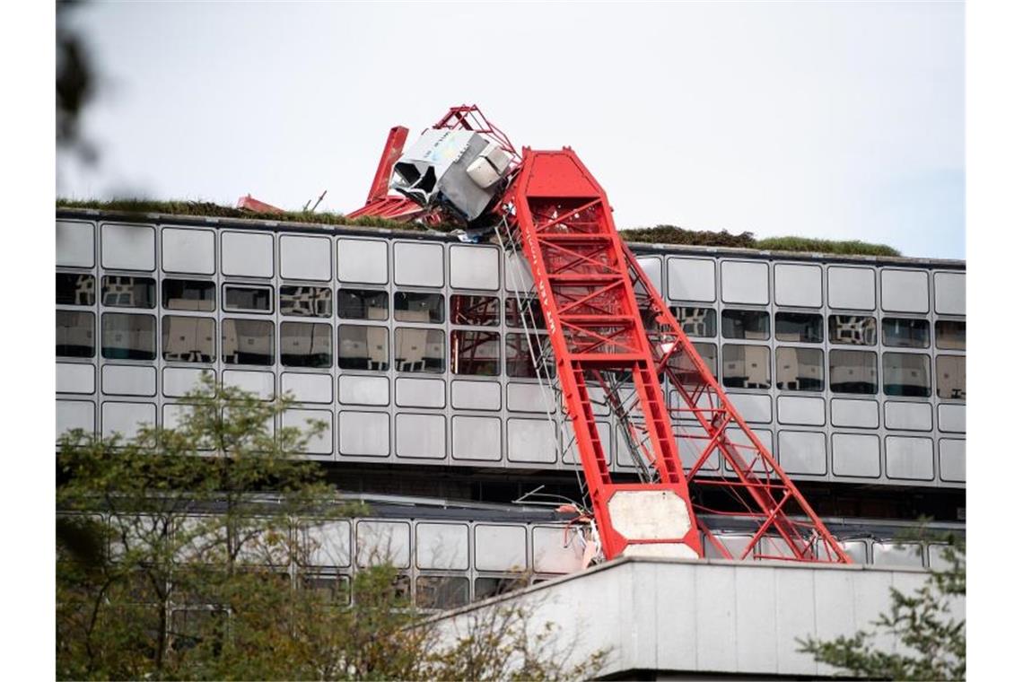 Verletzte bei Kran-Unfall in München Der Ausleger eines umgestürzten Baukrans lehnt an einer Hauswand. Foto: Matthias Balk/dpa