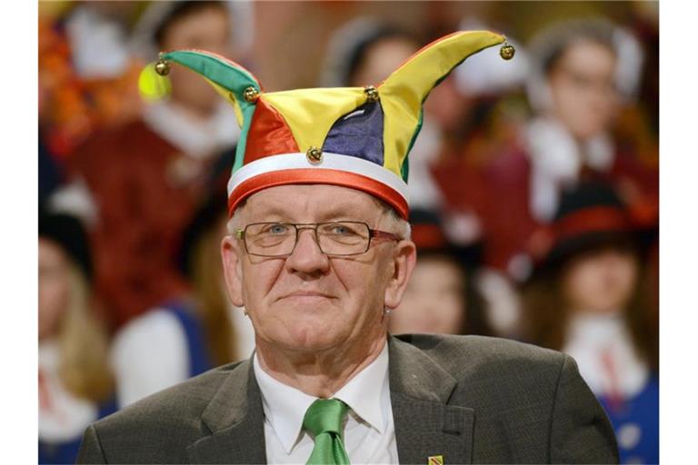 Der baden-württembergische Ministerpräsident Winfried Kretschmann (Bündnis 90/Die Grünen) trägt vor dem Narrengericht in Stockach nach seiner Verurteilung die Narrenmütze. Foto: picture alliance / dpa / Archivbild