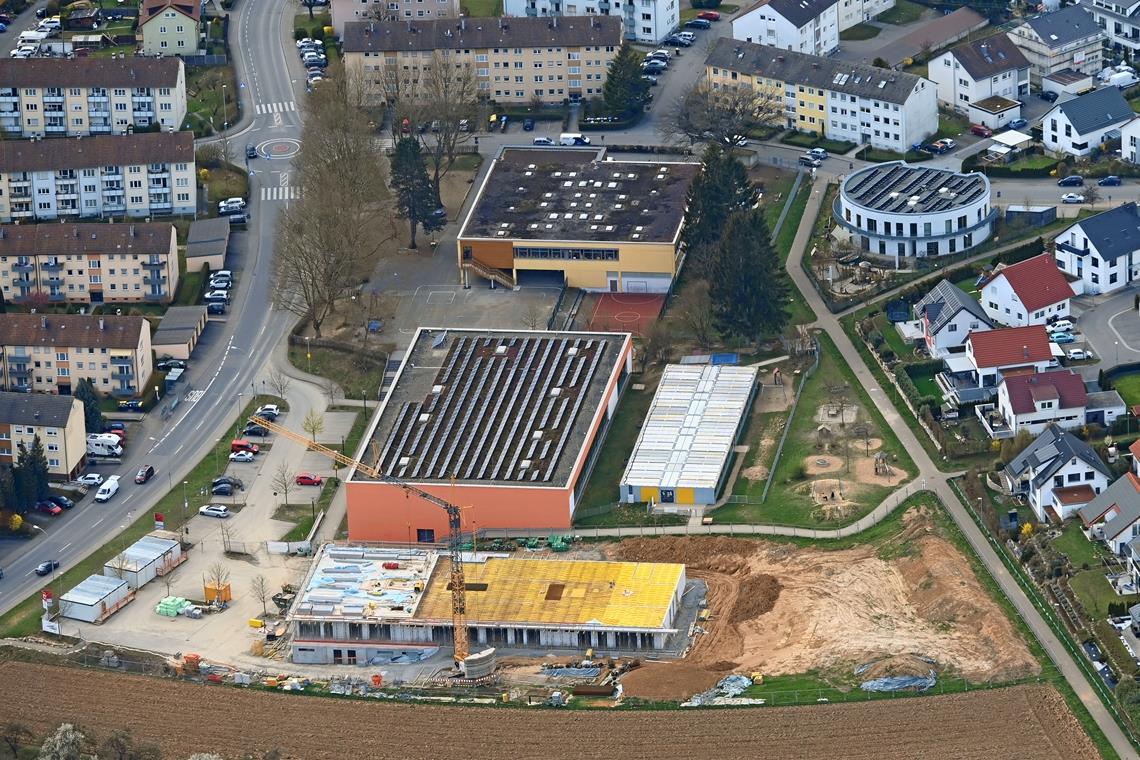 Der Baukörper der neuen Kita (im Vordergrund) ist in das abschüssige Gelände eingebettet. Das Provisorium aus Containern hinter der Sporthalle Katharinenplaisir wird abgebaut, sobald die neue Kindertagesstätte bezugsfertig ist. Das ist voraussichtlich im Sommer 2022 der Fall. Foto: W. Kuhnle