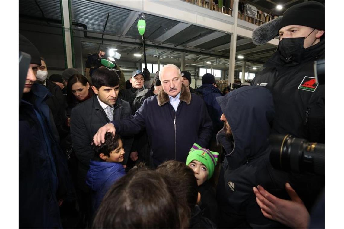 Der belarussische Machthaber Alexander Lukaschenko spricht mit Migranten in einem Logistikzentrum an der polnisch-belarussischen Grenze. Foto: BelTA/XinHua/dpa
