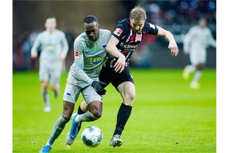 Der Berliner Dodi Lukebakio (l) im Laufduell mit dem Frankfurter Martin Hinteregger. Foto: Uwe Anspach/dpa