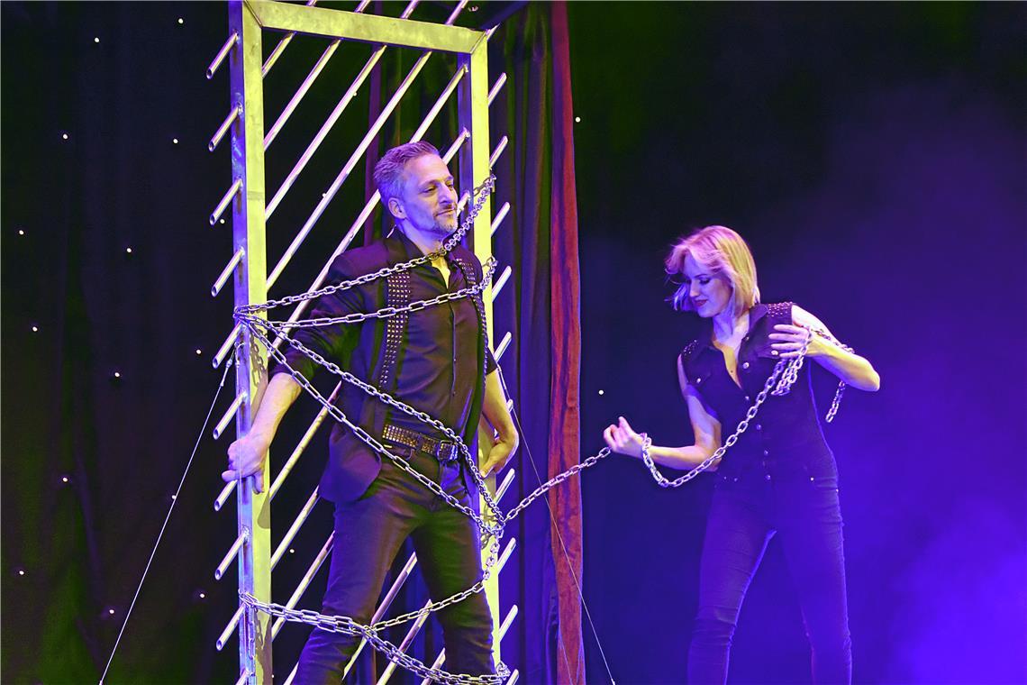 Große Zaubershow mit Peter Valance Der berühmte Zauberer wird von einer Assistentin in Ketten gelegt.