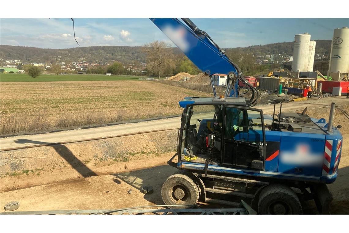 Der beschädigte Bagger steht an einer Baustelle neben den Bahngleisen.