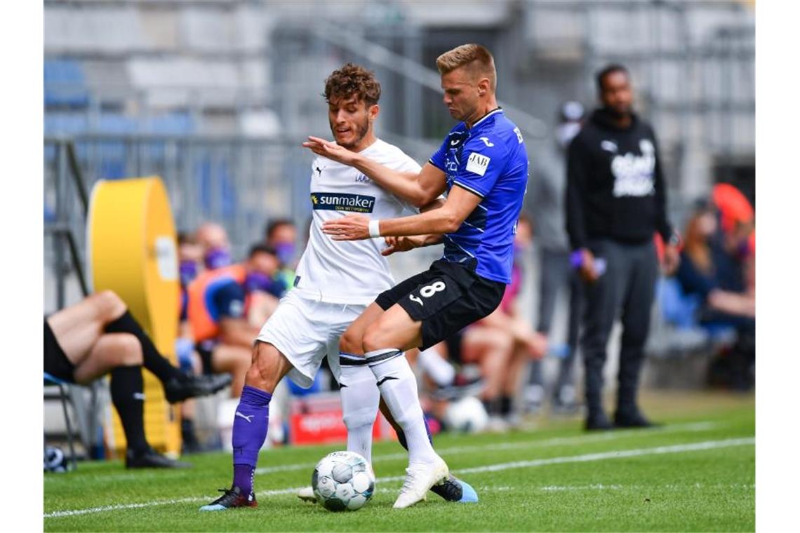 Der Bielefelder Florian Hartherz (r) im Zweikampf mit Bashkim Ajdini vom VfL Osnabrück. Foto: Stuart Franklin/Getty/POOL/dpa