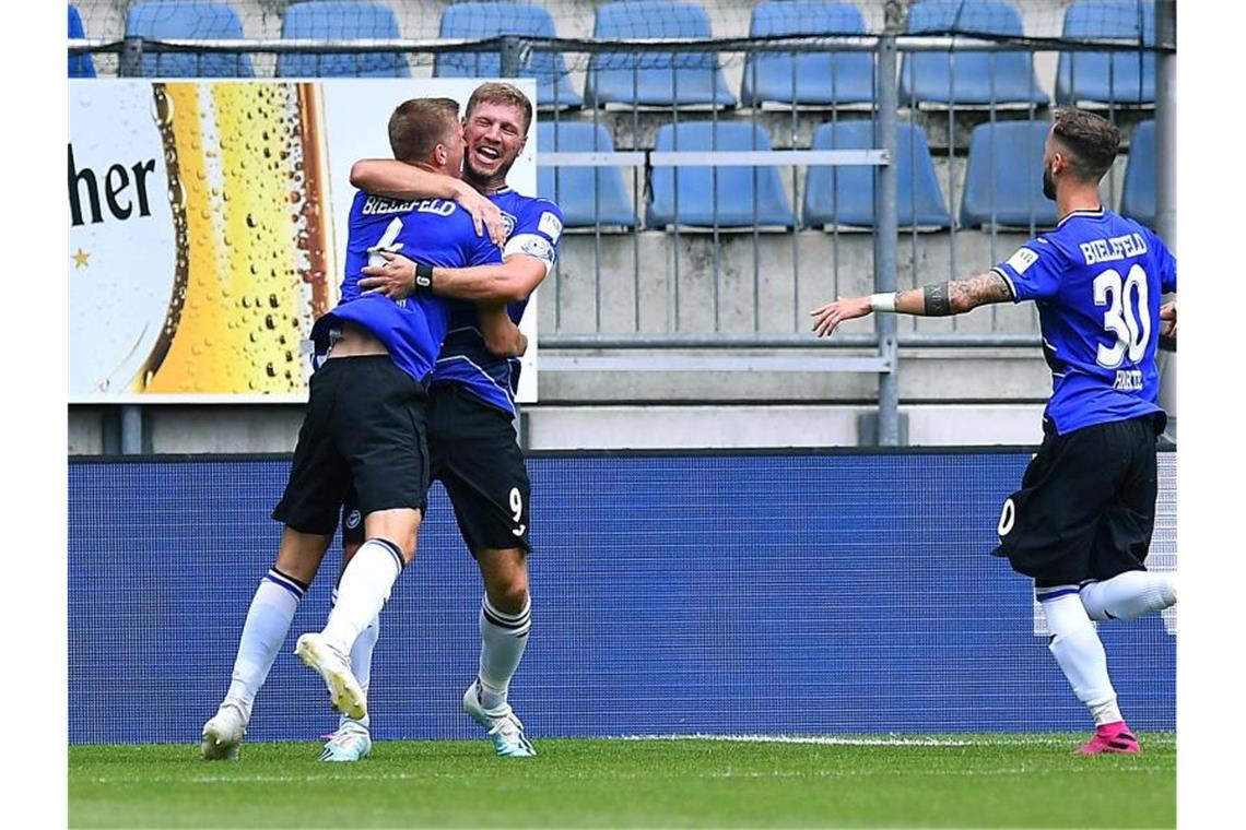 Der Bielefelder Joakim Nilsson lässt sich nach seinem Treffer von Fabian Klos und Marcel Hartel (l-r) feiern. Foto: Revierfoto