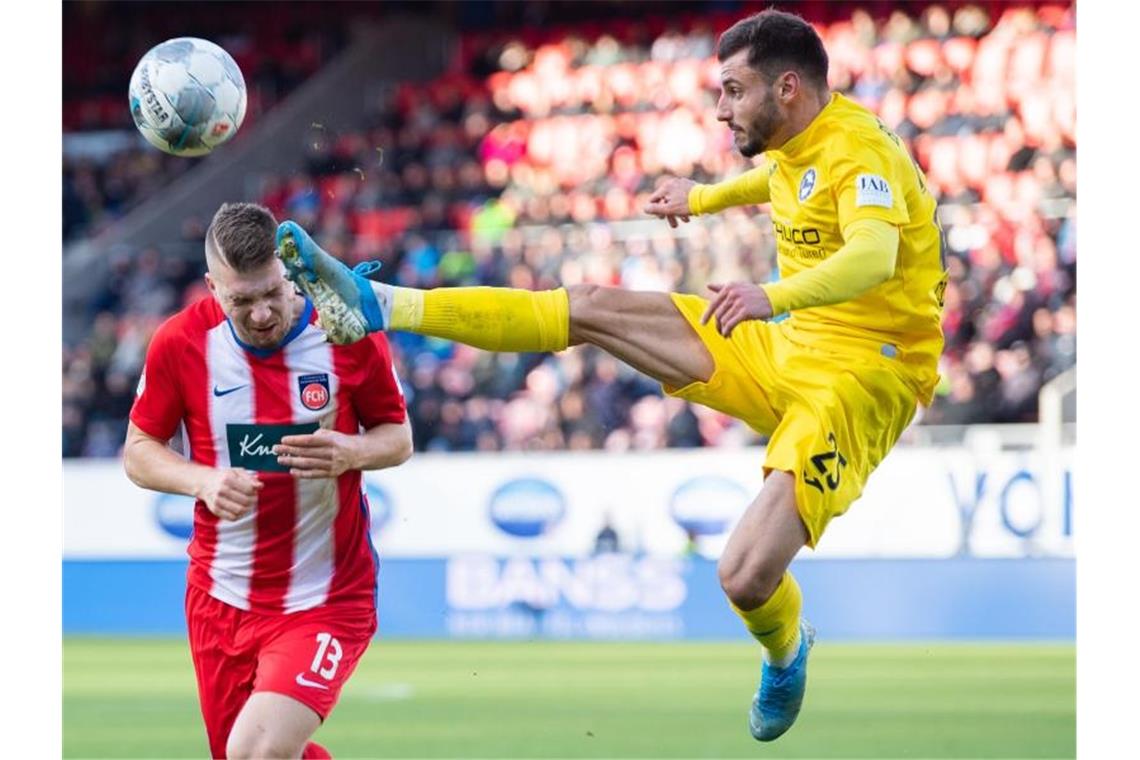 Der Bielefelder Jonathan Clauss (r) geht mit hohem Bein in den Zweikampf mit Robert Leipertz vom 1. FC Heidenheim. Foto: Tom Weller/dpa