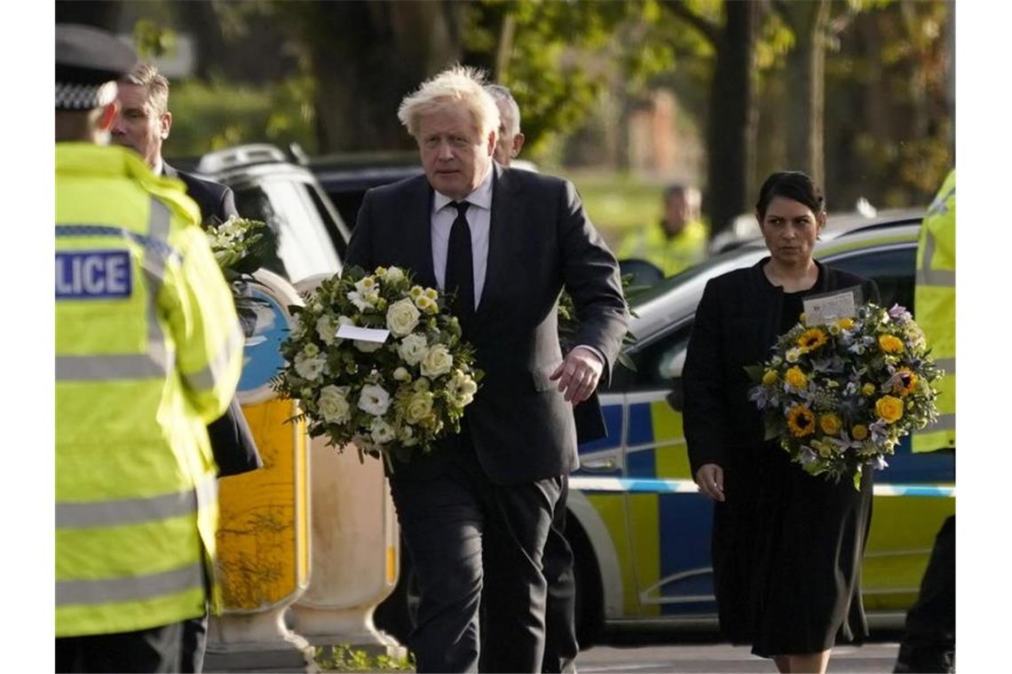 Attentat auf Abgeordneten löst Demokratiedebatte aus Der britische Premier Boris Johnson, gefolgt von Innenministerin Priti Patel mit Blumen in den Händen am Tatort. Foto: Alberto Pezzali/AP/dpa