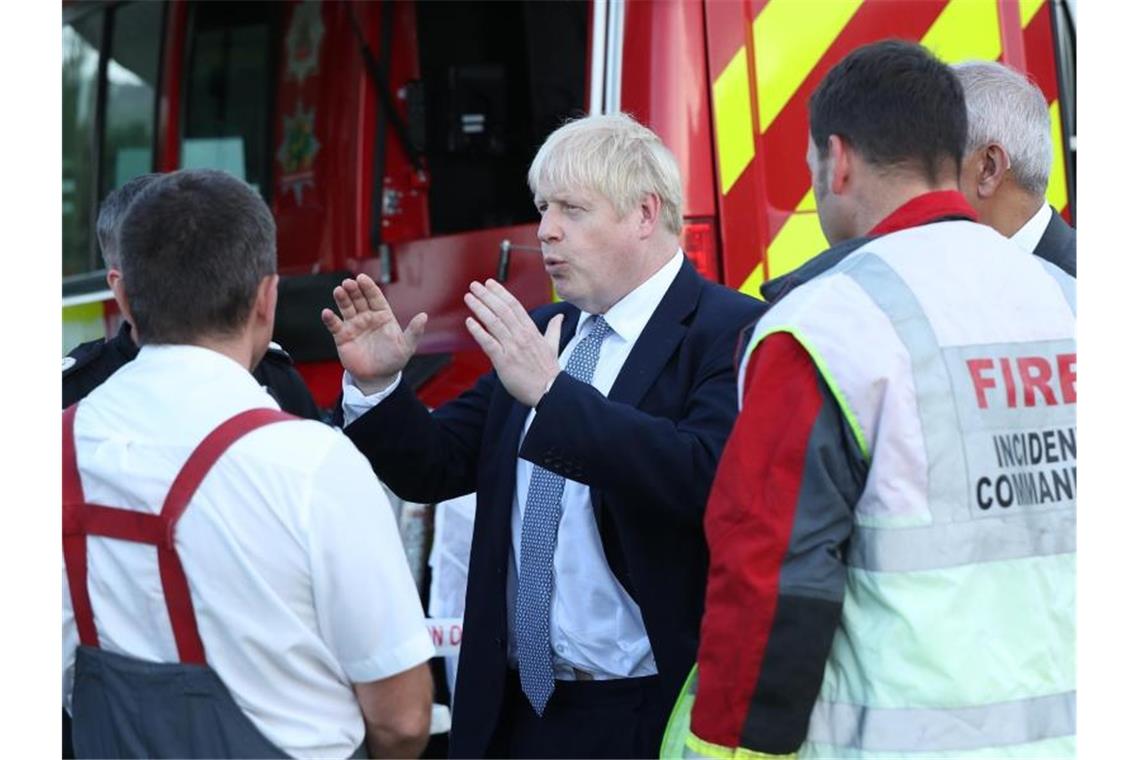 Der britische Premierminister Boris Johnson spricht während seines Besuchs in Whaley Bridge mit Einsatzkräften. Foto: Yui Mok/PA Wire