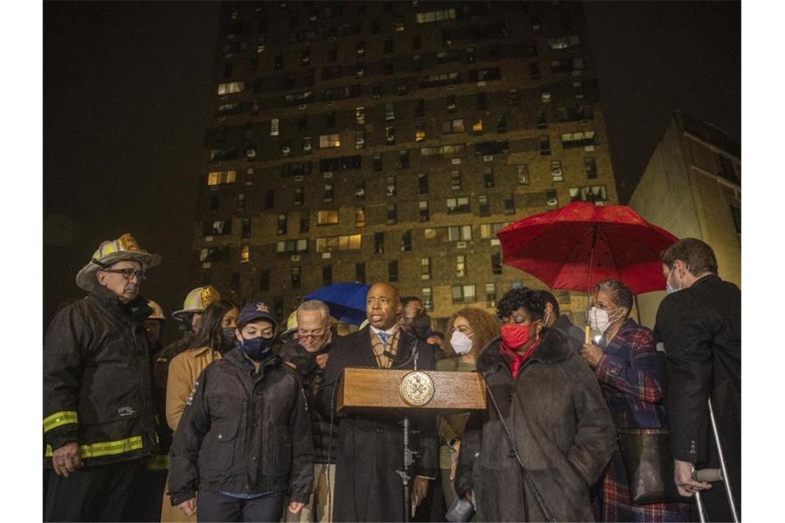 Trauer in New York nach schwerem Wohnhausbrand Der Bürgermeister von New York City, Eric Adams (M), spricht während einer Pressekonferenz vor dem Wohnhaus in der Bronx. Foto: Jeenah Moon/AP/dpa