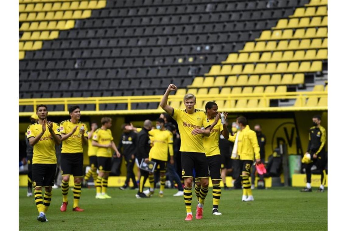 Geister-Schauspiel auf Bewährung: Re-Start fast unfallfrei Der BVB um Torjäger Erling Haaland (M.) feierten einen Derbysieg vor leeren Rängen. Foto: Martin Meissner/AP-Pool/dpa