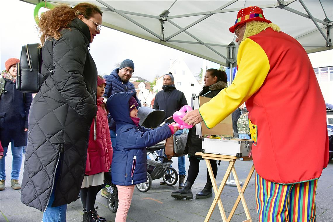 Der Clown macht Luftballonkunst und verteilt Hunde, Schmetterlinge, Katzen an di...