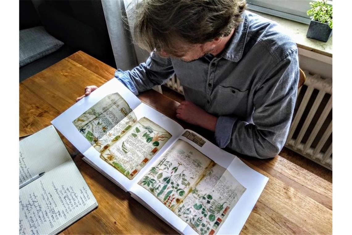 Der Computerlinguistiker Jürgen Hermes mit einem Faksimile des berühmten Voynich-Manuskripts. Foto: Privat Jürgen Hermes/dpa