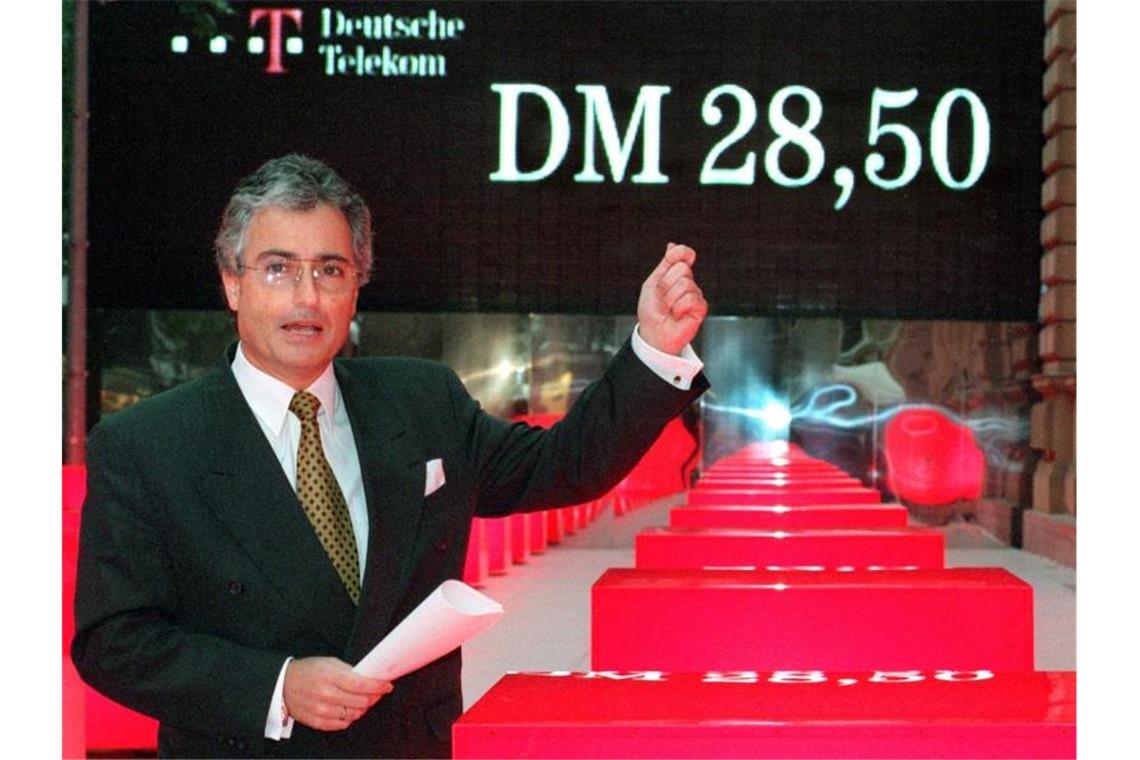 Der damalige Vorstandsvorsitzende der Deutschen Telekom, Ron Sommer, zeigt vor der Deutschen Börse auf die Anzeigentafel, auf der der Erstausgabepreis von 28,50 DM für die Telekom-Aktie zu lesen ist. Foto: Stephanie Pilick/dpa