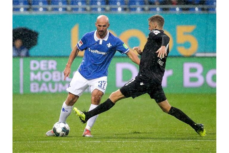 Der Darmstädter Patrick Herrmann (l) im Zweikampf mit Marc Lorenz vom Karlsruher SC. Foto: Hasan Bratic/dpa