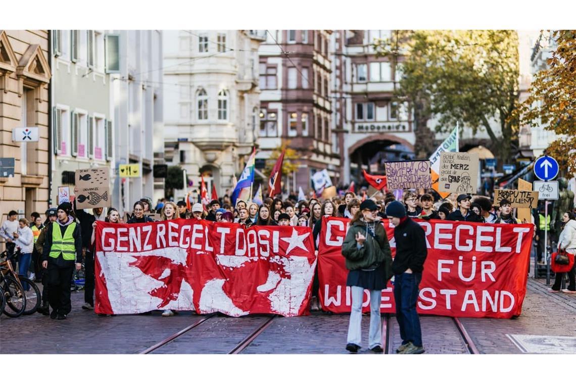 Der Demonstrationszug zieht mit Bannern mit der Aufschrift "Gen Z regelt das!" und "Gen Z Regelt Zeit für Widerstand" durch die Innenstadt von Freiburg.